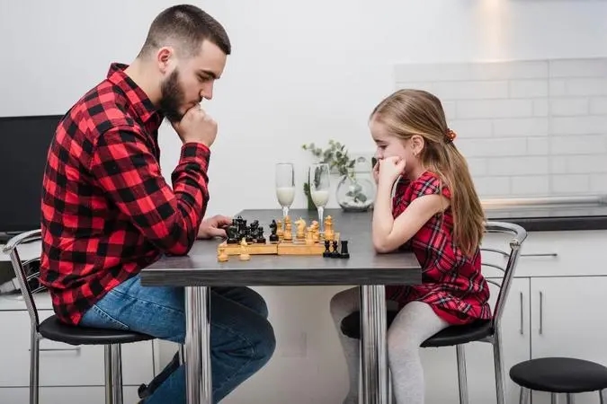 father daughter playing chess