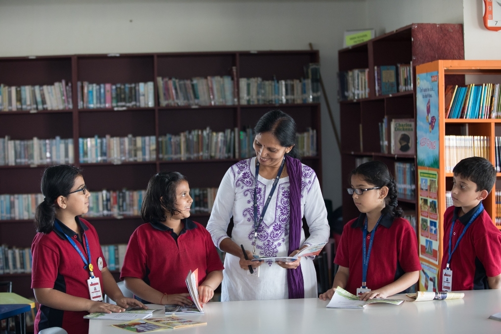 "Teacher discussing world affairs and current events with students in a classroom, encouraging active participation."