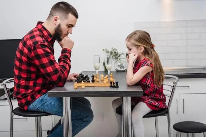 father daughter playing chess
