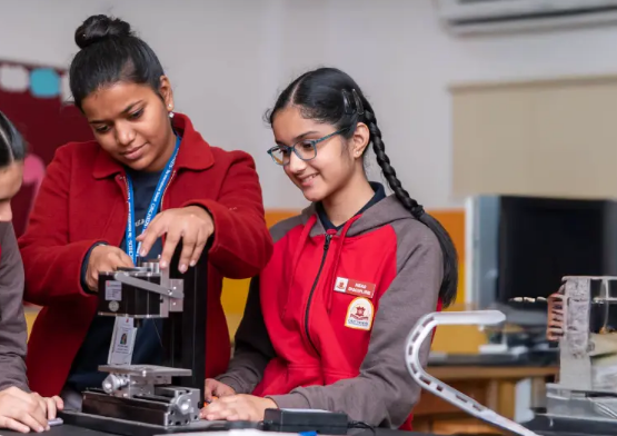 Students working together on a robotics project, assembling a mechanical structure in a lab setting.