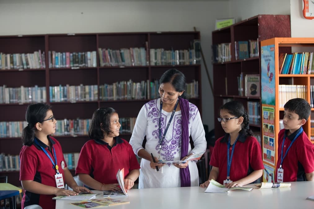 "Teacher discussing world affairs and current events with students in a classroom, encouraging active participation."