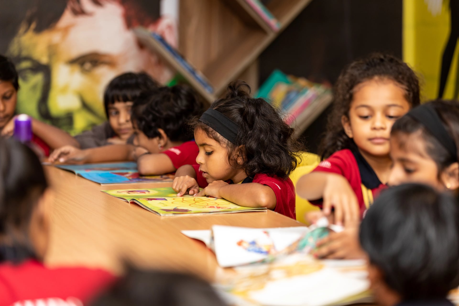 Young children reading books together in a classroom library during a guided learning activity