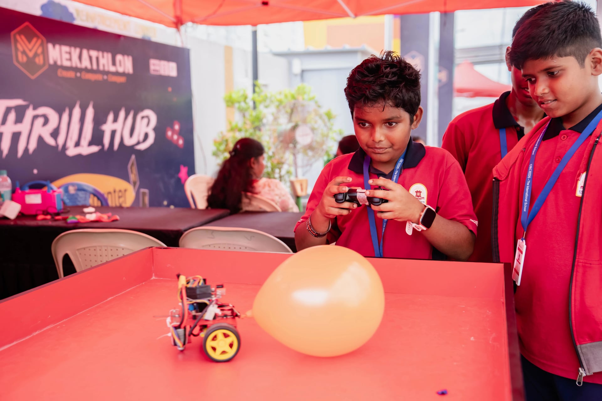 A student operating a remote-controlled robot during a challenge at Mekathlon.