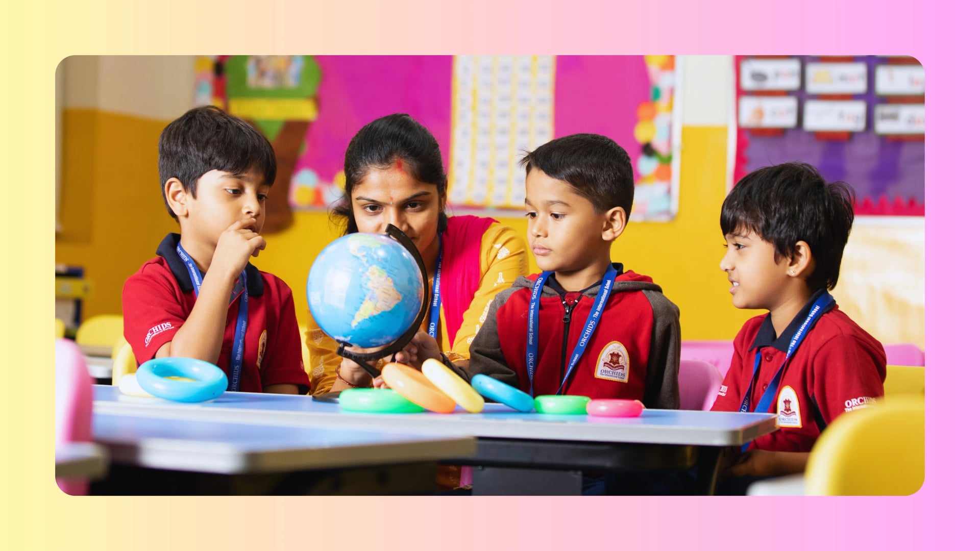 Children wearing school uniforms engage in a classroom activity under teacher guidance.